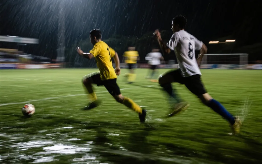 球员在雨夜奔跑拼抢，附加赛的意志与对抗